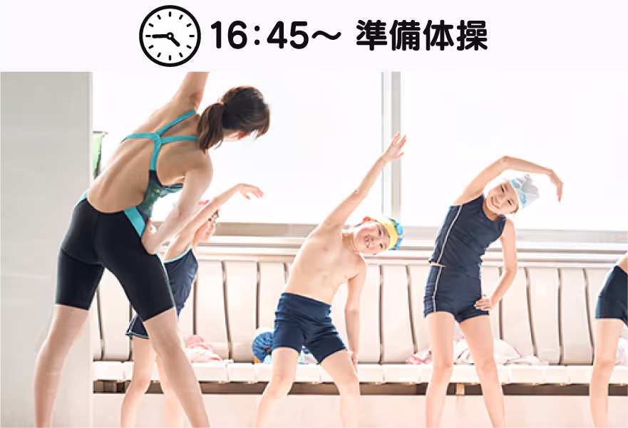 女性インストラクターと子どもたちが水泳帽をかぶって準備体操をしている。