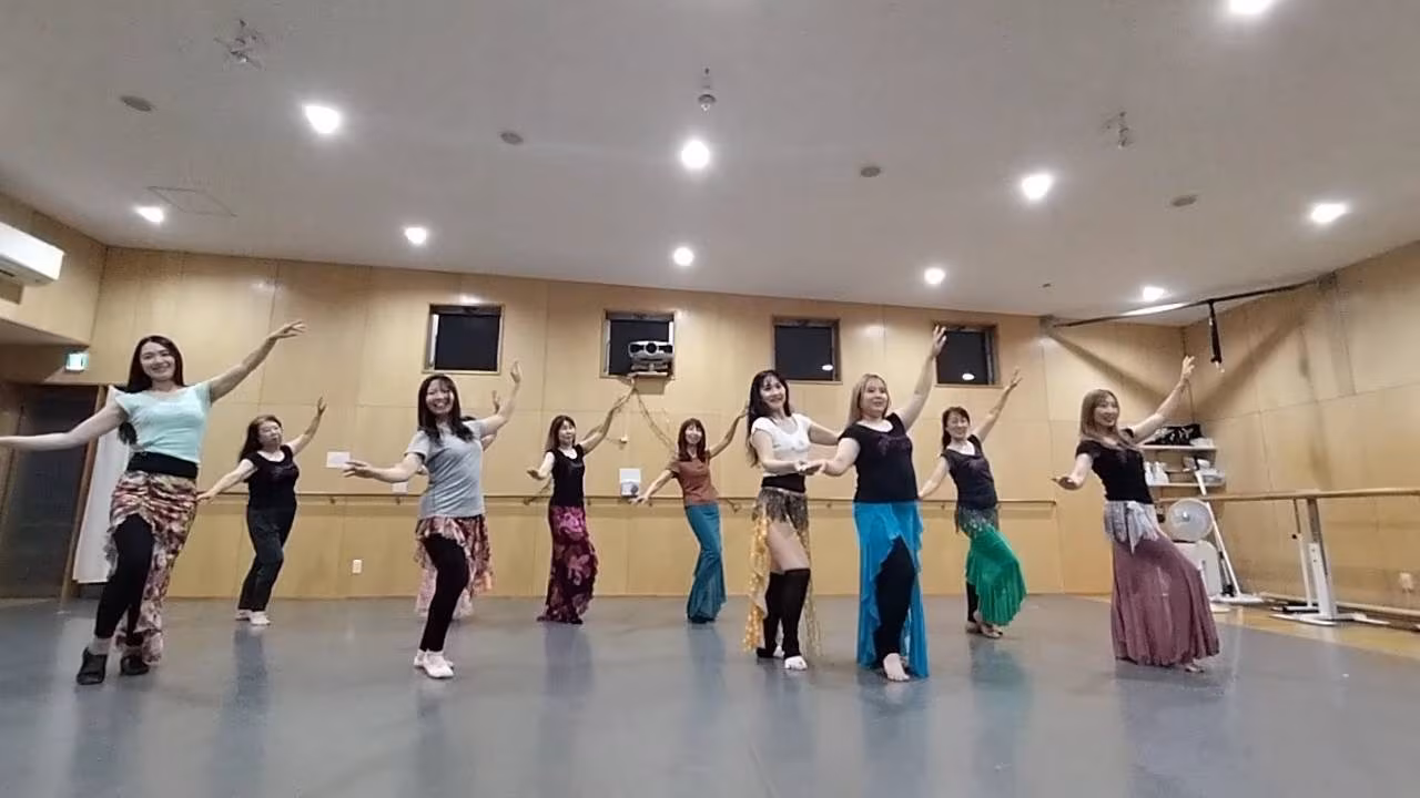 アールイースタジオのベリーダンス講座で、腰にヒップスカーフを巻いた受講生たちが並んで踊るレッスン風景。