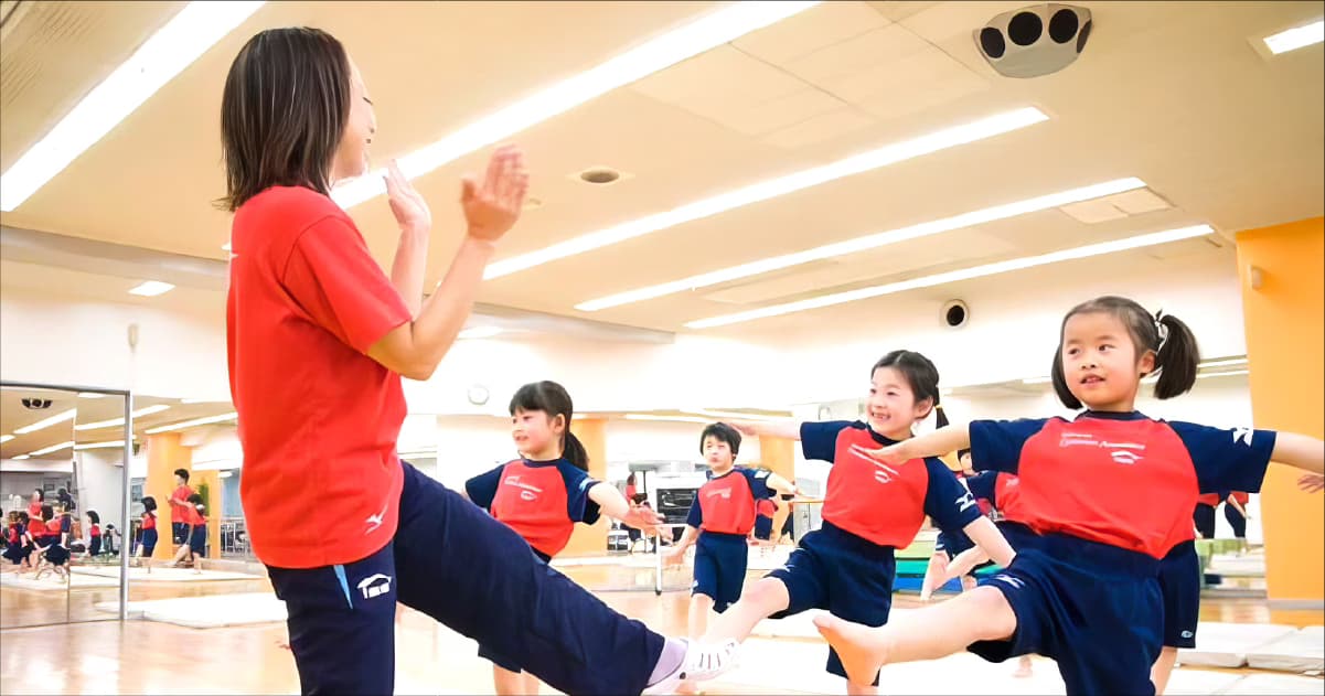 体操教室で子どもたちと笑顔の指導者