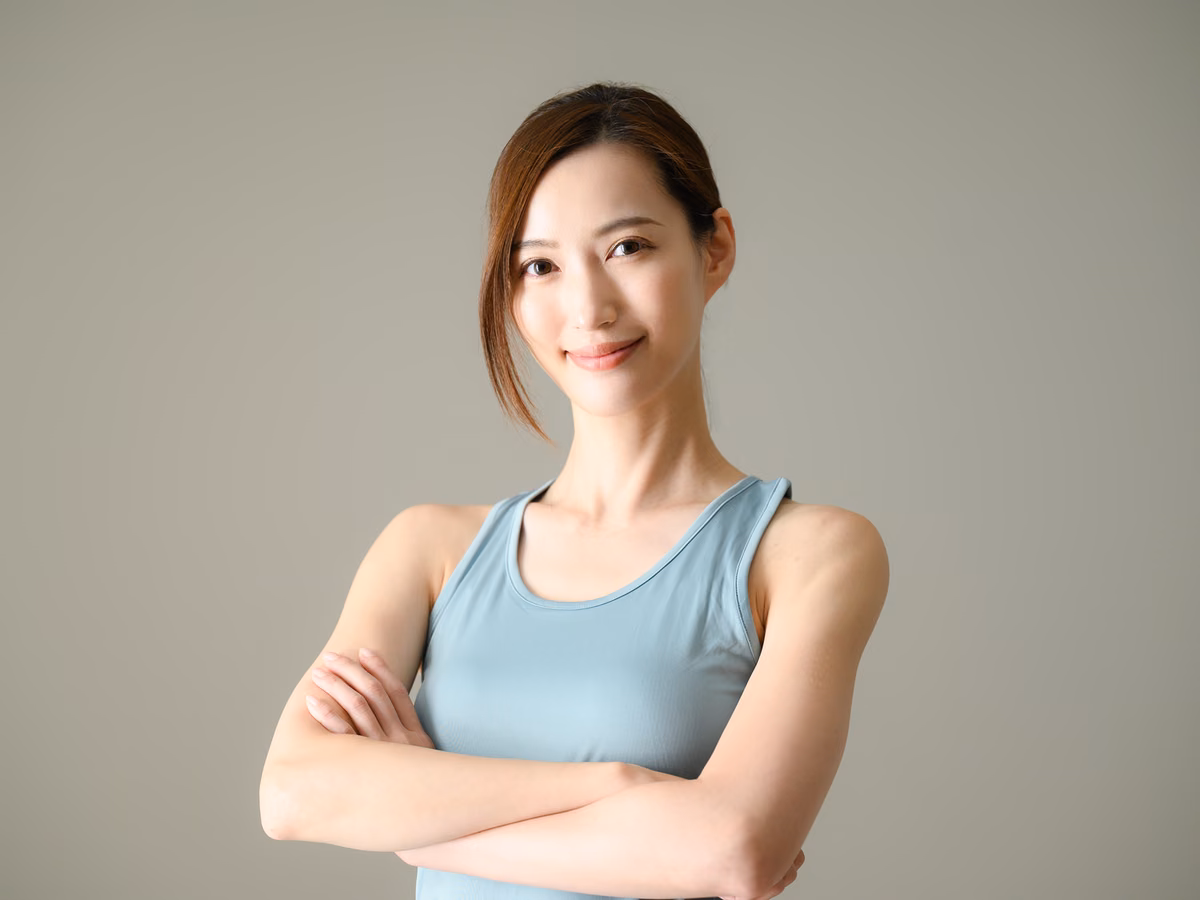 腕を組んで座るトレーニングウェアの女性。
